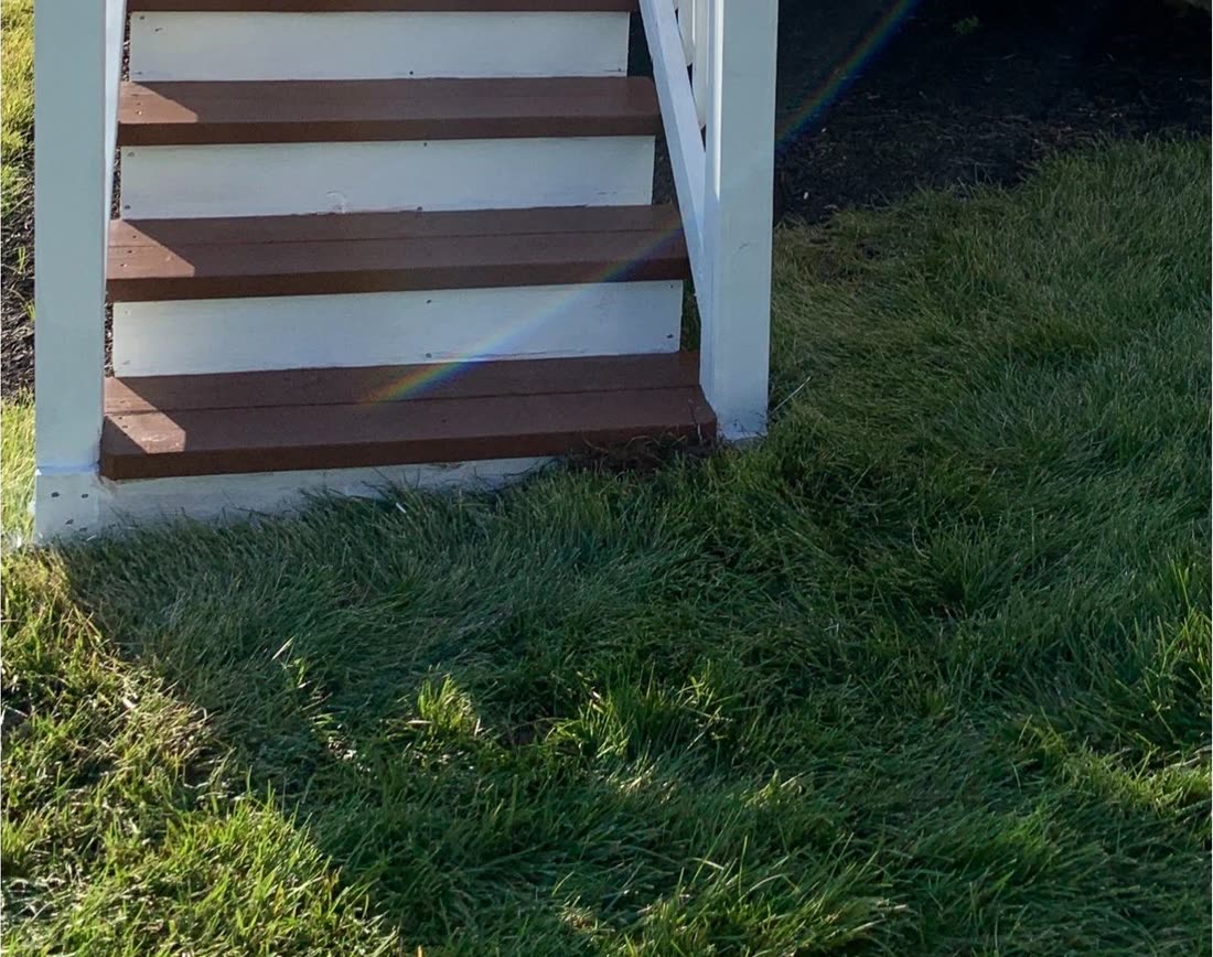 The same deck after cleaning and sealing, rich colour and white rails