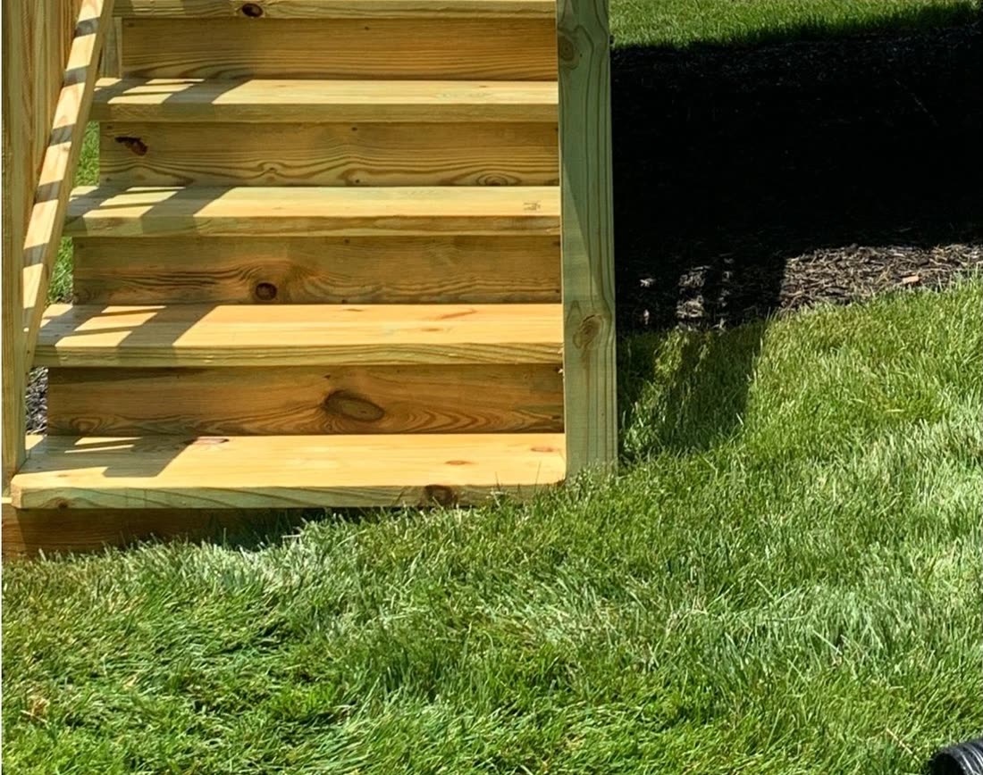 A bare timber deck and steps before restoration