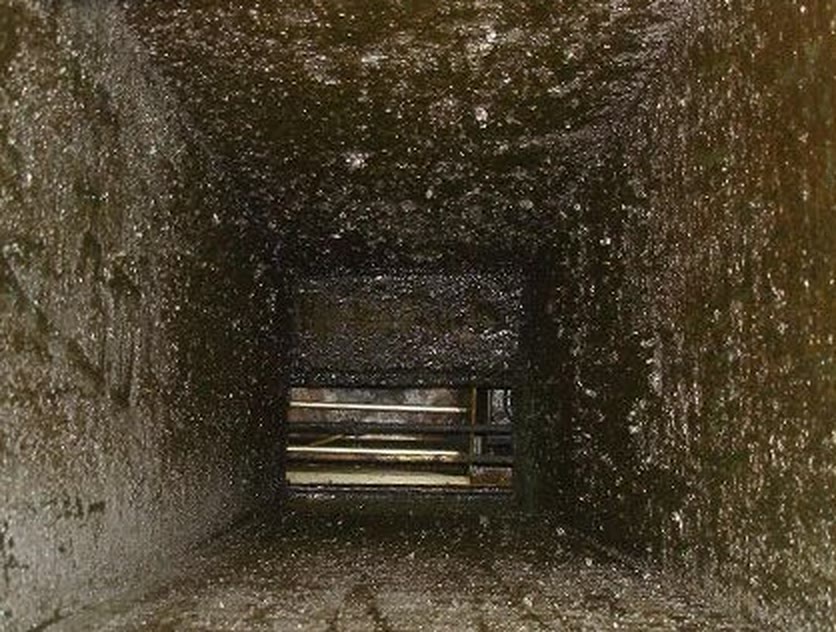 The inside of a kitchen exhaust duct before cleaning, walls caked with grease