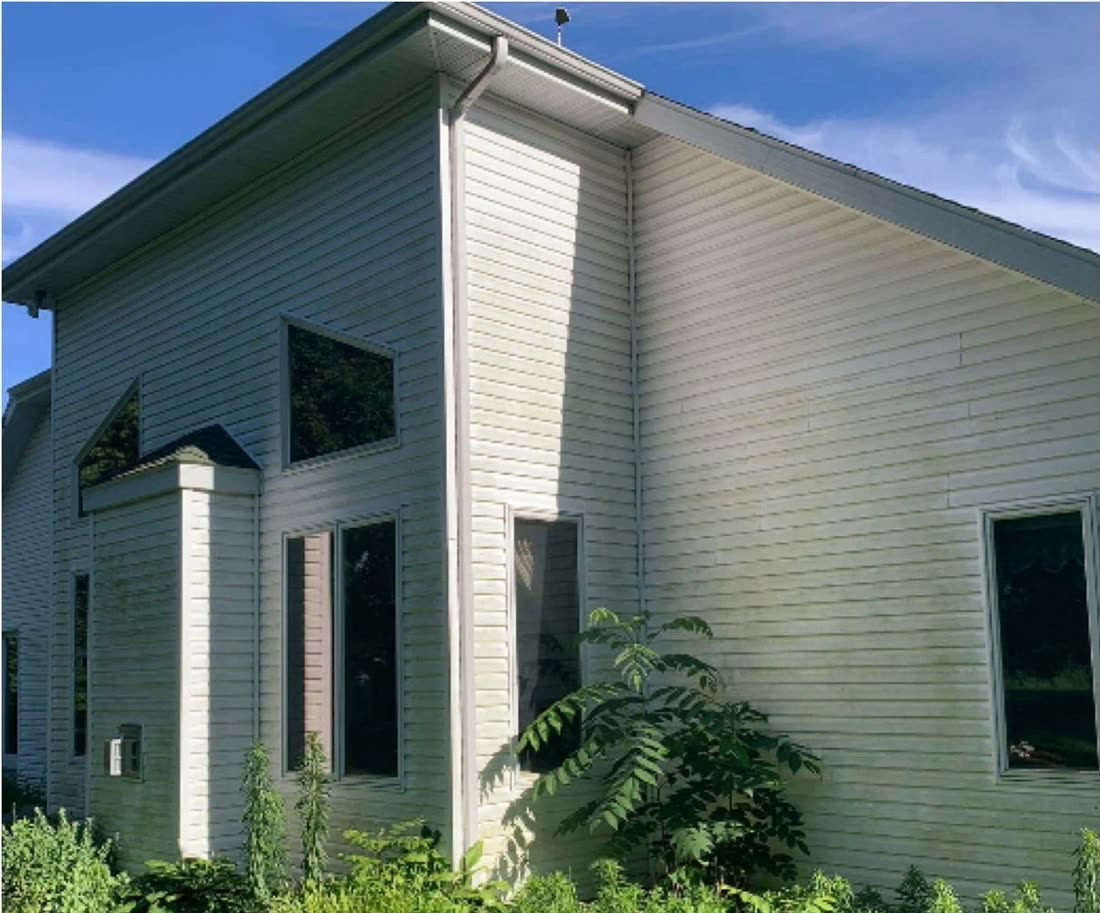 A house exterior dulled by algae and dirt before washing