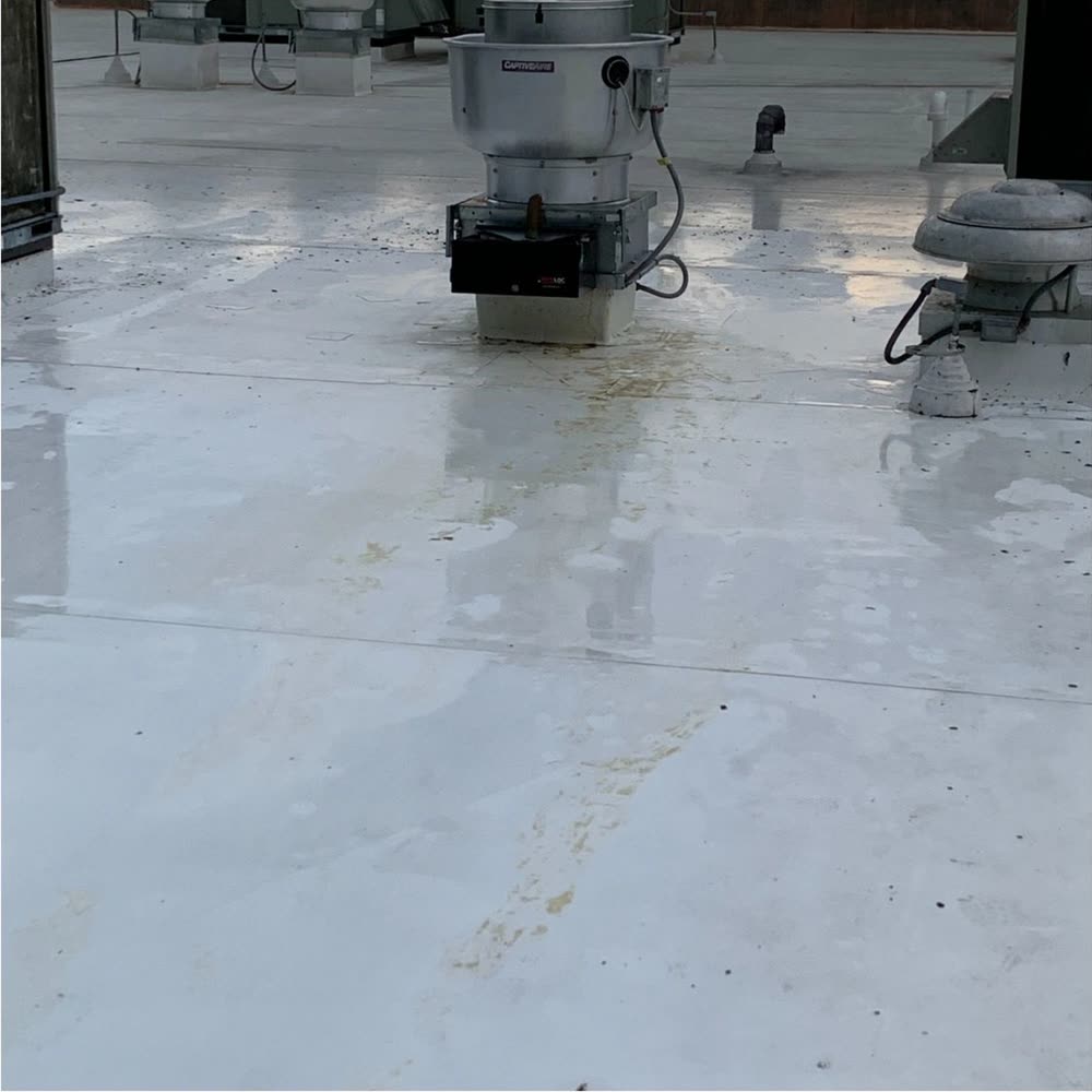 The same rooftop fan and membrane after cleaning, the grease trail gone